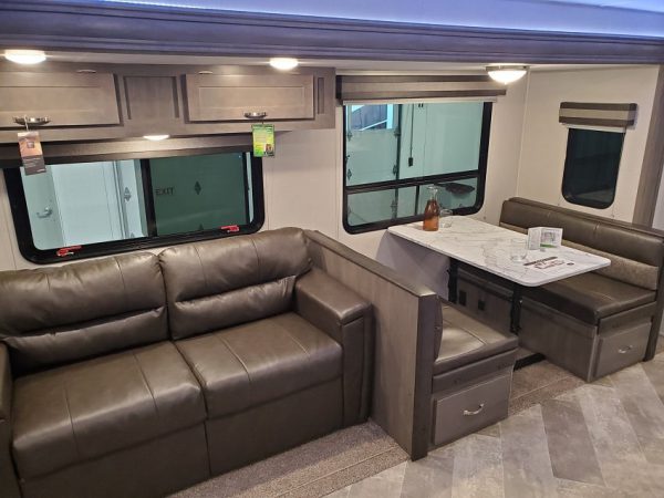 View of the dinette and couch inside the 2021 Alta Travel Trailers 2850-KRL