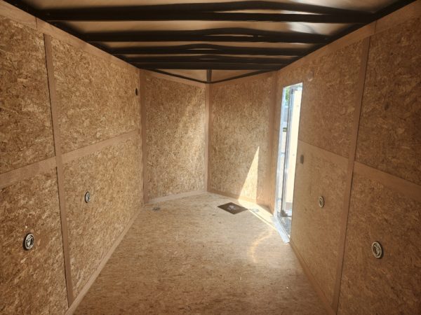 View of the 7ft. interior and man door on the 2023 US Cargo 7x16 Rear Ramp enclosed trailer
